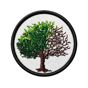 May include: Embroidered patch featuring a tree split down the middle. One half is lush green with leaves, the other is brown with bare branches. The patch is circular with a black border and a white background.