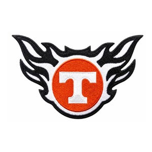 Puede incluir: Parche bordado con la letra "T" blanca dentro de un círculo naranja, bordeado con blanco y motivos de llamas negras. Diseñado para coser o planchar sobre tela. Artículo decorativo.