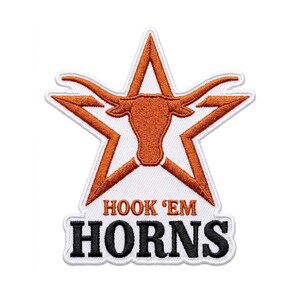 May include: Embroidered patch featuring a burnt orange longhorn head inside a star, with a white border. The text "HOOK 'EM HORNS" is below the star in black letters with a white border. The patch is on a white background.