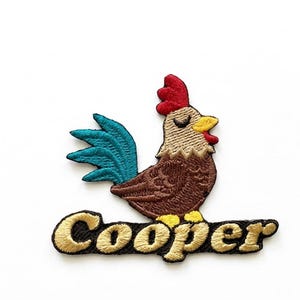 May include: Embroidered patch featuring a cartoon rooster with a red comb, brown body, teal tail feathers, and yellow beak and feet. The patch has the name "Cooper" embroidered in gold lettering on a black background.