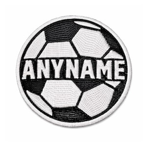 Pode incluir: Remendo bordado com um design de bola de futebol em preto e branco. O texto "ANYNAME" é bordado em branco no centro. O remendo é redondo e tem uma borda branca.