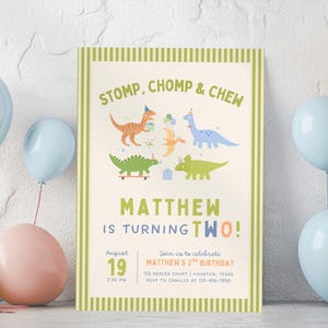 Op de afbeelding: Een rechthoekige verjaardagsuitnodiging met een groen gestreepte rand, voorzien van illustraties van vijf kleurrijke dinosaurussen met feesthoedjes. De tekst luidt: STOMP, CHOMP & CHEW, MATTHEW IS TURNING TWO, 19 augustus, 14:30 uur en details.