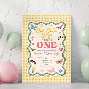 May include: A rectangular birthday invitation card with a yellow and white gingham background. The text reads Our Cute Bug IS TURNING ONE, Please join us to celebrate Sophie's 1st Birthday, August 11, 12-2 PM, 123 Magnolia Court, New Orleans, LA, RSVP TO CAMILLE AT 123.456.7890. The card features a green vine border with colourful butterflies, flowers, and hearts.