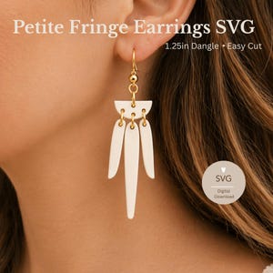 May include: Cream-colored Petite Fringe Earrings with gold-colored accents. The earrings have a 1.25-inch dangle and are designed for easy cutting. The text "Petite Fringe Earrings SVG" is displayed at the top of the image.