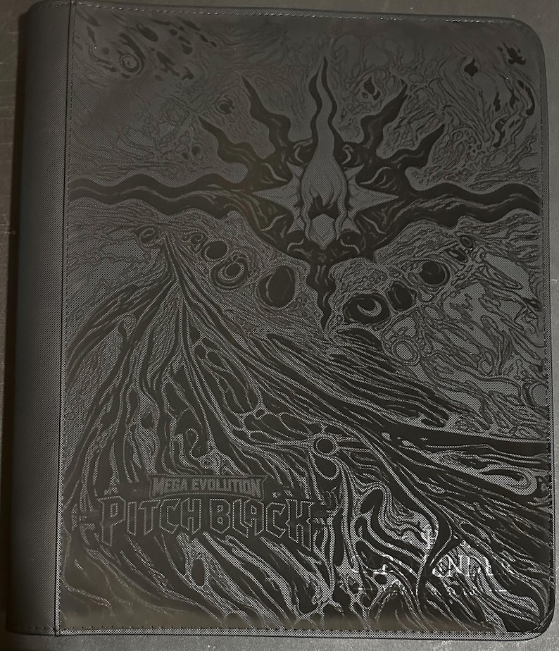 May include: A black trading card binder featuring a dark, intricate embossed design of a central star-like figure surrounded by flowing, abstract patterns. The text "MEGA EVOLUTION" and "PITCH BLACK" is printed in a bold, stylized font on the front cover.