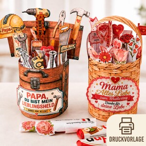 Könnte beinhalten: Zwei dekorative Papierarbeiten: eine Werkzeugkiste mit Werkzeugen und dem Text "PAPA, DU BIST MEIN LIEBLINGSHELD" und ein Korb mit Blumen und dem Text "Mama Alles Liebe zum Muttertag". Die Werkzeugkiste hat einen gelben Helm, Bohrer und Hammer.