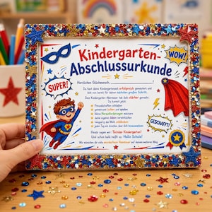 Pode incluir: Um certificado retangular intitulado Kindergarten-Abschlussurkunde com tema de super-herói, apresentando uma criança de capa, gráficos de estrelas e texto. A moldura é decorada com lantejoulas vermelhas, azuis e douradas e estrelas nos cantos.