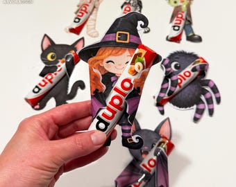 Può includere: Una collezione di ritagli di carta a tema Halloween progettati per contenere barrette di cioccolato Duplo. I personaggi includono una strega, un gatto nero, una mummia, uno scheletro, un mostro di Frankenstein, un ragno e un pipistrello.