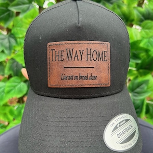 Op de afbeelding: Een witte keramische mok met een zwarte handgreep en de tekst "But First, Coffee" in een zwarte, handgeschreven lettertype. De mok staat op een wit oppervlak.