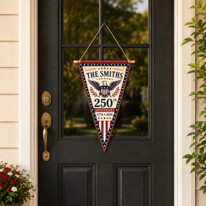 May include: A triangular pennant hanging from a wooden dowel with a string. The design features a bald eagle, the text THE SMITHS, 250TH ANNIVERSARY, and 1776-2026. The color scheme is red, white, and blue with a star-patterned border and vertical stripes.