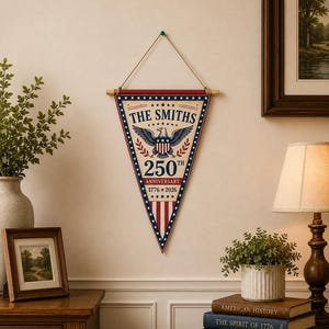 May include: A triangular wall pennant featuring a patriotic design with a central eagle emblem, the text THE SMITHS, 250TH ANNIVERSARY, and 1776-2026. The banner has a red, white, and blue color scheme with stars and stripes, suspended by a wooden rod.