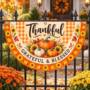 Peut inclure: Une bannière en éventail semi-circulaire avec un motif à carreaux orange et blanc, des tournesols, des feuilles d'automne et trois citrouilles. Le texte indique Thankful, Grateful & Blessed en lettres noires avec un petit cœur orange.