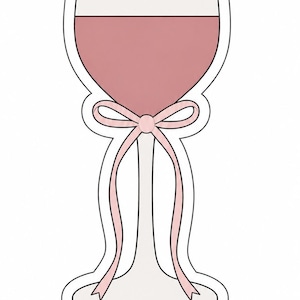 May include: A wine glass-shaped design with a pink bow. The glass is filled with a pink liquid, and the bow is tied around the stem. The design has a white outline and is set against a white background.