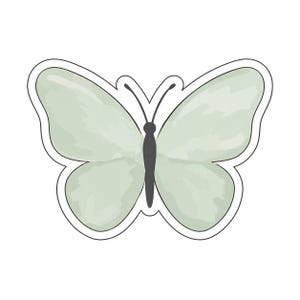 Pode incluir: Um autocolante de borboleta verde claro com efeito aquarela. A borboleta tem um corpo e antenas pretas e um contorno branco. As asas são de uma cor verde suave e suave.