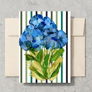 May include: A rectangular greeting card featuring an abstract alcohol ink illustration of blue flowers with green and yellow stems. The background consists of vertical stripes in shades of dark green, light green, and black on a white field.