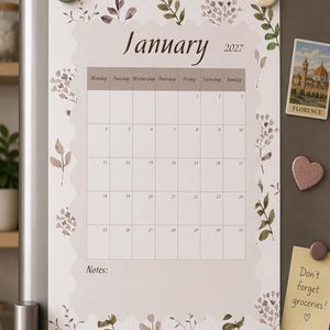 Puede incluir: Un calendario de pared para enero de 2027 con una cuadrícula central festoneada sobre un fondo beige claro. El borde está decorado con ilustraciones botánicas en acuarela de hojas y flores en tonos verdes y marrones.