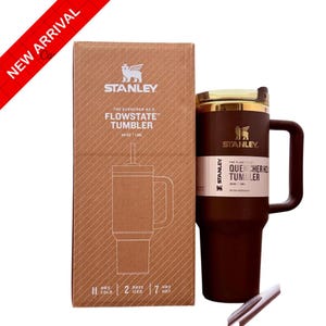 Puede incluir: Un vaso Stanley Flowstate Quencher H2.0 marr&oacute;n con asa y pajita, junto a su caja de cart&oacute;n. La caja presenta el logotipo de Stanley y los detalles del producto. El vaso es de 1,18L.
