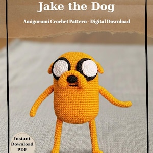 Puede incluir: Amigurumi de ganchillo de Jake el Perro, un personaje de Adventure Time, en amarillo brillante con detalles blancos y negros. La imagen incluye el texto "Jake the Dog" y "Amigurumi Crochet Pattern - Digital Download."