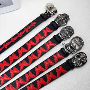 May include: A white ceramic mug with a black handle and the text "But First, Coffee" in a bold, black font. The mug is set against a blurred background, suggesting a cosy setting.