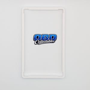 Pu&ograve; includere: Una custodia rettangolare bianca con un logo blu e bianco che recita "OBD Collectables". La custodia ha un bordo rialzato ed &egrave; posta su uno sfondo bianco. Il logo &egrave; in un carattere stilizzato.