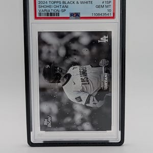 Pu&ograve; includere: Una carta da baseball in bianco e nero con Shohei Ohtani con la divisa dei Los Angeles Dodgers. La carta &egrave; valutata e protetta in un supporto. La carta include "2024 Topps Black & White" e "Variation-SP". La carta &egrave; della serie B&W.