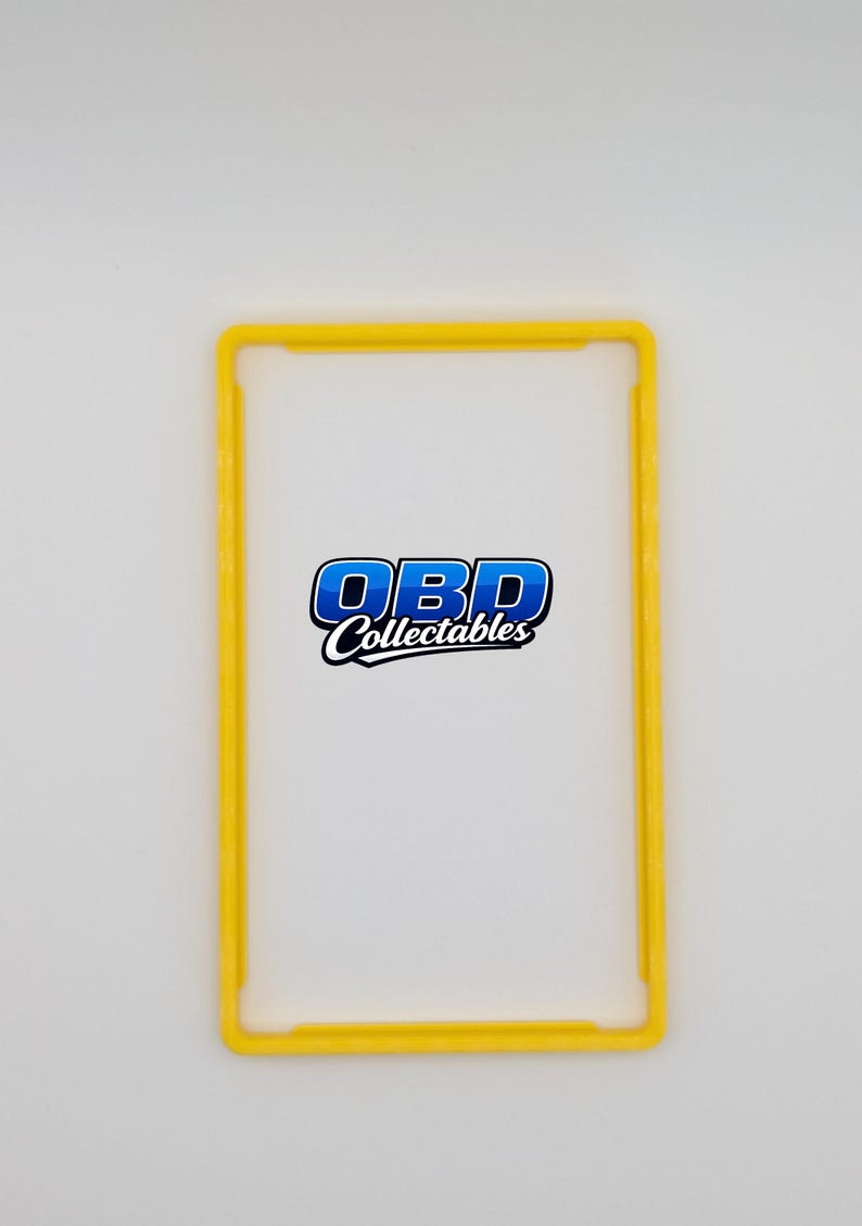 Pu&ograve; includere: Una cornice rettangolare gialla con angoli arrotondati. La cornice circonda uno sfondo bianco con il testo "OBD Collectables" in blu e bianco. La cornice &egrave; di un colore giallo brillante.
