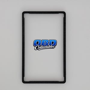 Pu&ograve; includere: Una cornice rettangolare nera con angoli arrotondati. La cornice circonda uno spazio bianco, con il testo blu e bianco "OBD Collectables" centrato all'interno. Lo sfondo &egrave; grigio chiaro.