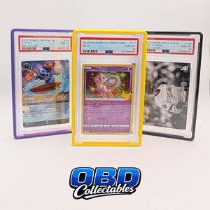 Pu&ograve; includere: Tre carte collezionabili in custodie protettive. Le carte presentano Stitch di Disney Lorcana, una carta Mew Pok&eacute;mon e una carta Topps Black & White di Shohei Ohtani. Le custodie sono incorniciate in viola, giallo e nero. Il logo "OBD Collectables" &egrave; in basso.