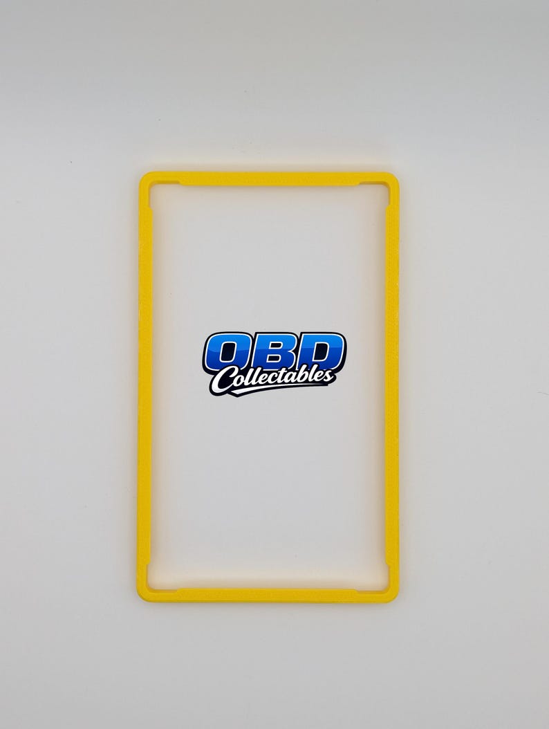 Pu&ograve; includere: Una cornice rettangolare gialla con angoli arrotondati. La cornice circonda un'area trasparente e trasparente. Il testo "OBD Collectables" &egrave; visualizzato in blu e bianco all'interno dello spazio trasparente.