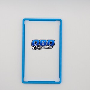 Pu&ograve; includere: Una vetrina rettangolare in plastica trasparente con un bordo blu brillante. Il testo "OBD Collectables" &egrave; visualizzato in un logo blu e bianco al centro della vetrina. La vetrina &egrave; progettata per contenere e proteggere oggetti da collezione.