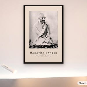 May include: A framed black and white portrait of Mahatma Gandhi sitting in a draped cloth, with the text "MAHATMA GANDHI" and "Portrait 1913 South Africa" printed below. The framed print measures 24 by 36 inches as indicated by the text.