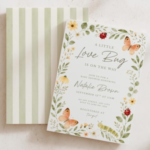 May include: A rectangular baby shower invitation card featuring a watercolor botanical border with butterflies, ladybugs, and a caterpillar. The text reads A LITTLE LOVE BUG IS ON THE WAY, honoring Natalie Brown on September 12th at 11AM. Includes a striped envelope.