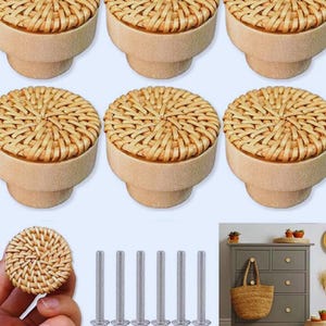 May include: A set of six decorative cabinet knobs. Each knob features a woven rattan top and a light-colored wooden base. The image also shows six silver screws, likely for installation, and a hand holding one knob.