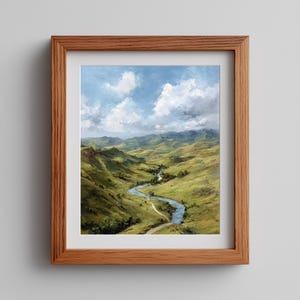 Pode incluir: Uma pintura de paisagem emoldurada retrata um vale com colinas verdes e um rio sinuoso sob um céu azul com nuvens brancas fofas. A obra de arte está em uma moldura de madeira marrom.