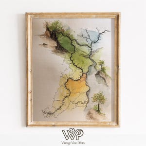 May include: Framed watercolor map print with a gold-colored wooden frame. The map features a detailed depiction of a region with green, yellow, and blue hues, with black lines indicating roads or rivers. The bottom of the frame has the text "Vintage Vine Prints".