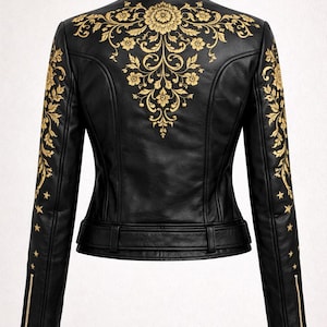 May include: Black leather jacket with gold floral embroidery on the back and sleeves. It has a stand-up collar, zip sleeves, and a belted waist. The jacket is a classic biker style with an elegant touch. The jacket's measurements are in centimetres.