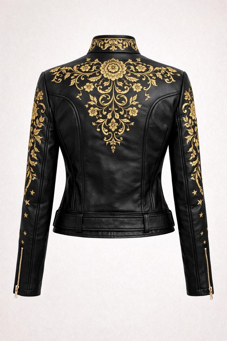 May include: Black leather jacket with gold floral embroidery on the back and sleeves. It has a stand-up collar, zip sleeves, and a belted waist. The jacket is a classic biker style with an elegant touch. The jacket's measurements are in centimetres.