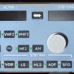 Könnte beinhalten: Eine hellblaue Flugzeugbedienungstafel mit mehreren Knöpfen und Digitalanzeigen. Das Panel enthält Beschriftungen wie "ACTIVE", "STBY/CRS", "VHF1", "HF1", "NAV" und "ON/OFF". Es hat einen Drehknopf und mehrere kleine schwarze Schrauben an den Rändern.