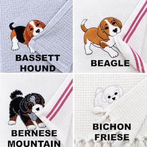 May include: Four waffle-weave kitchen towels featuring embroidered puppies. Top left: Basset Hound on grey. Top right: Beagle on white with red stripes. Bottom left: Bernese Mountain Dog on white with red stripes. Bottom right: Bichon Frise on white.