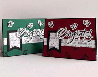 May include: Two graduation cards with the word "Congrats" in cursive. One card is dark green, the other is burgundy. Both cards have a black banner and leaf accents. The background has a subtle printed pattern.