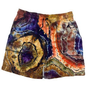 May include: Tie-dye shorts in a vibrant mix of colours, including purple, orange, brown, and blue. The shorts feature a drawstring waist and pockets. The fabric has a unique, swirling pattern.