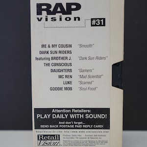 May include: A vintage Rap Vision cassette tape with a cream-colored cover. The cover features the title "RAP vision" in bold black letters, along with a list of song titles and artist names. The tape is marked with the number "#31".