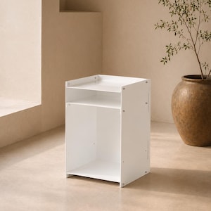 May include: A white bedside table with a rectangular frame, featuring an open top shelf and a larger open bottom storage compartment. The unit is constructed from flat panels joined by visible metal screws on the side panels, creating a clean, functional storage piece.
