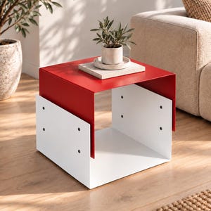 May include: A square side table constructed from a red metal top piece that overlaps two white metal side panels. The panels are secured with visible black screws on each side, creating an open-frame design with a flat surface for storage.