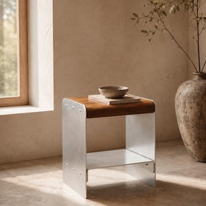 Puede incluir: Una mesa auxiliar moderna con tapa de madera y patas de metal cepillado. Un cuenco pequeño y una bandeja rectangular están sobre la mesa. La mesa tiene un estante. La habitación tiene una ventana y un jarrón grande.