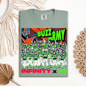 Puede incluir: Camiseta verde salvia con un gr&aacute;fico del ej&eacute;rcito de Buzz Lightyear. El dise&ntilde;o incluye las palabras "BUZZ ARMY" en verde, "INFINITY X 50" en rosa y verde, y "COLLECTORS EDITION".