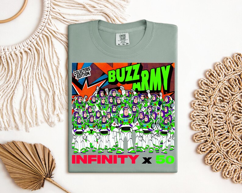 Puede incluir: Camiseta verde salvia con un gr&aacute;fico del ej&eacute;rcito de Buzz Lightyear. El dise&ntilde;o incluye las palabras "BUZZ ARMY" en verde, "INFINITY X 50" en rosa y verde, y "COLLECTORS EDITION".
