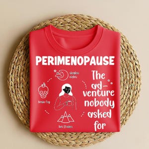 Puede incluir: Una camiseta roja de cuello redondo con la palabra "PERIMENOPAUSE" en blanco. La camiseta presenta ilustraciones y texto en blanco, incluyendo "brain fog", "sleepless nights" y "The adventure nobody asked for."