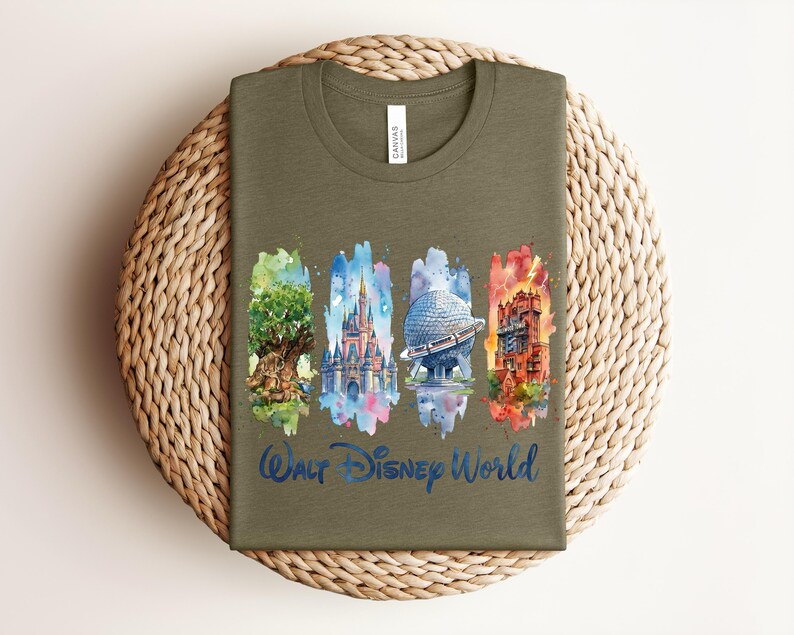 May include: An olive green t-shirt featuring watercolor illustrations of iconic Walt Disney World landmarks. The design includes the Tree of Life, Cinderella Castle, Spaceship Earth, and the Tower of Terror, with "Walt Disney World" in blue script.