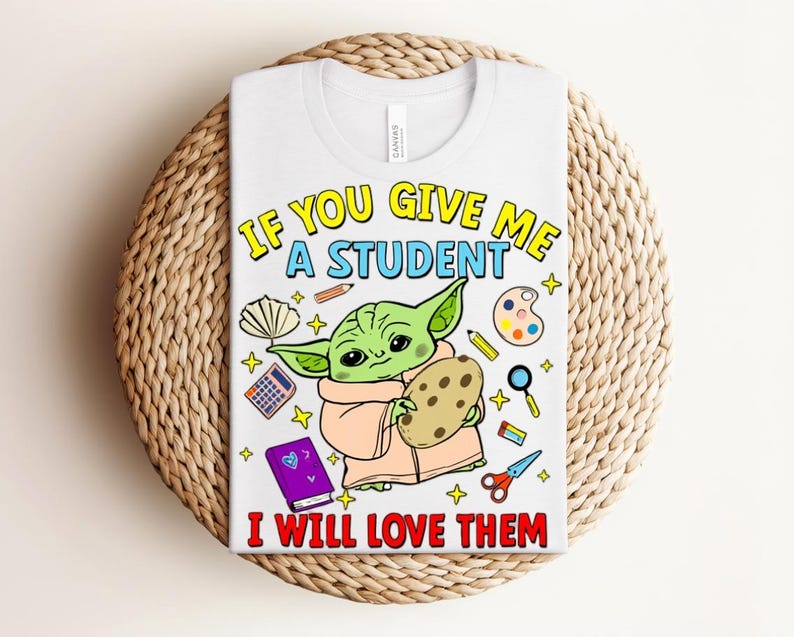 May include: White t-shirt featuring a cartoon character holding a cookie, surrounded by school supplies. The text reads, "IF YOU GIVE ME A STUDENT I WILL LOVE THEM" in yellow, blue, and red.